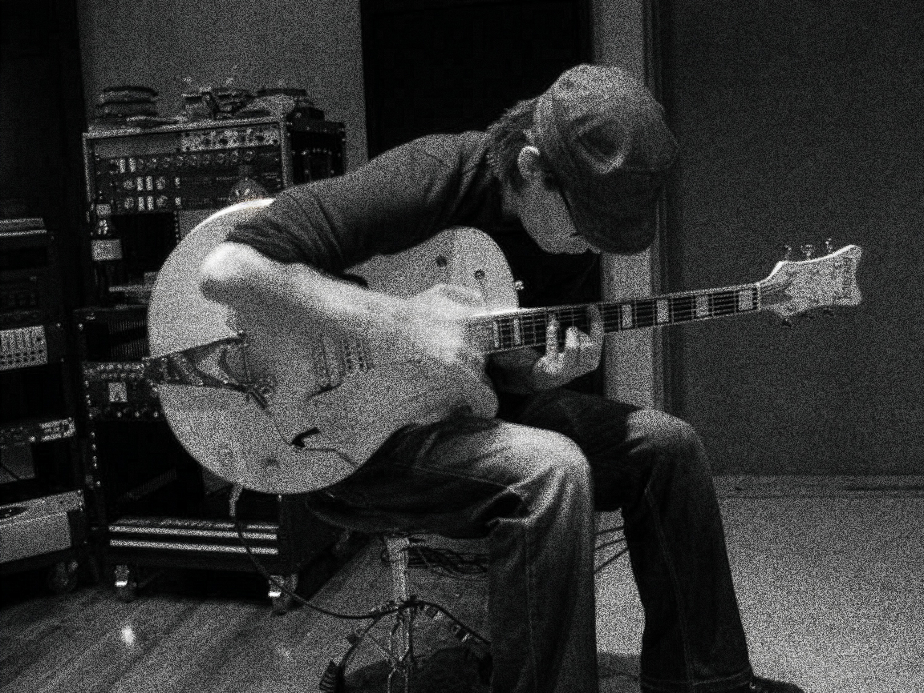 Ramon Galvan playing guitar in a studio.